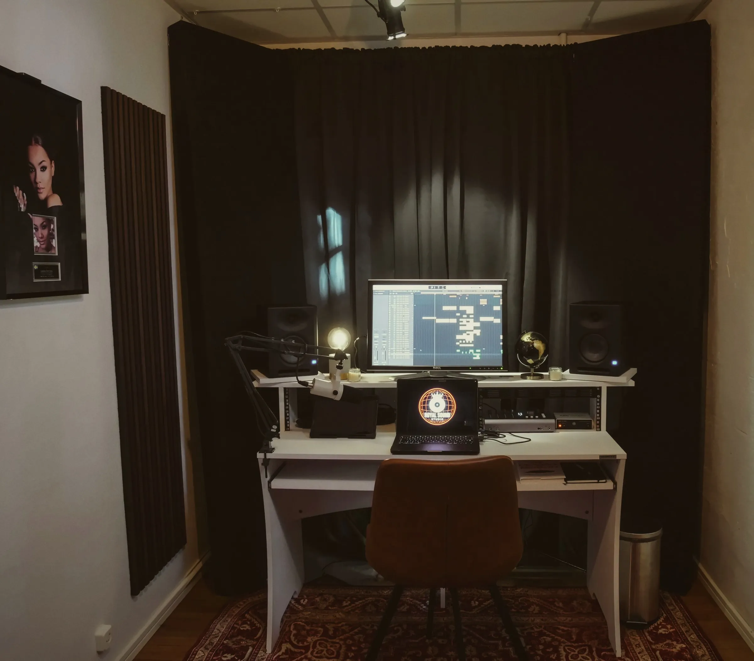 Ruby with the desk in front of black drapes